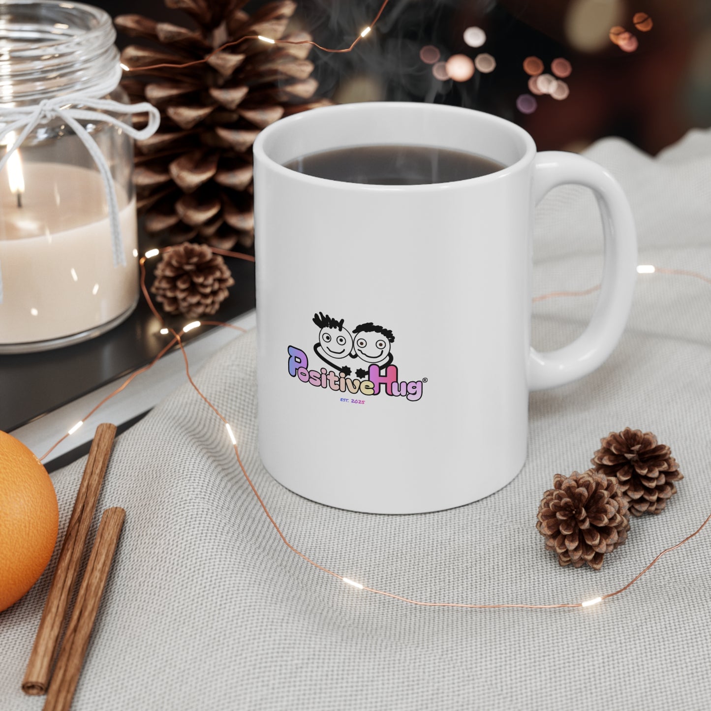 White mug with hot chocolate, surrounded by decorative elements like a candle, cinnamon sticks, and pine cones on a table.
