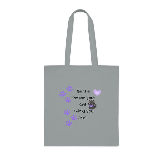 Gray tote bag with a cat-themed message and paw prints on a white background