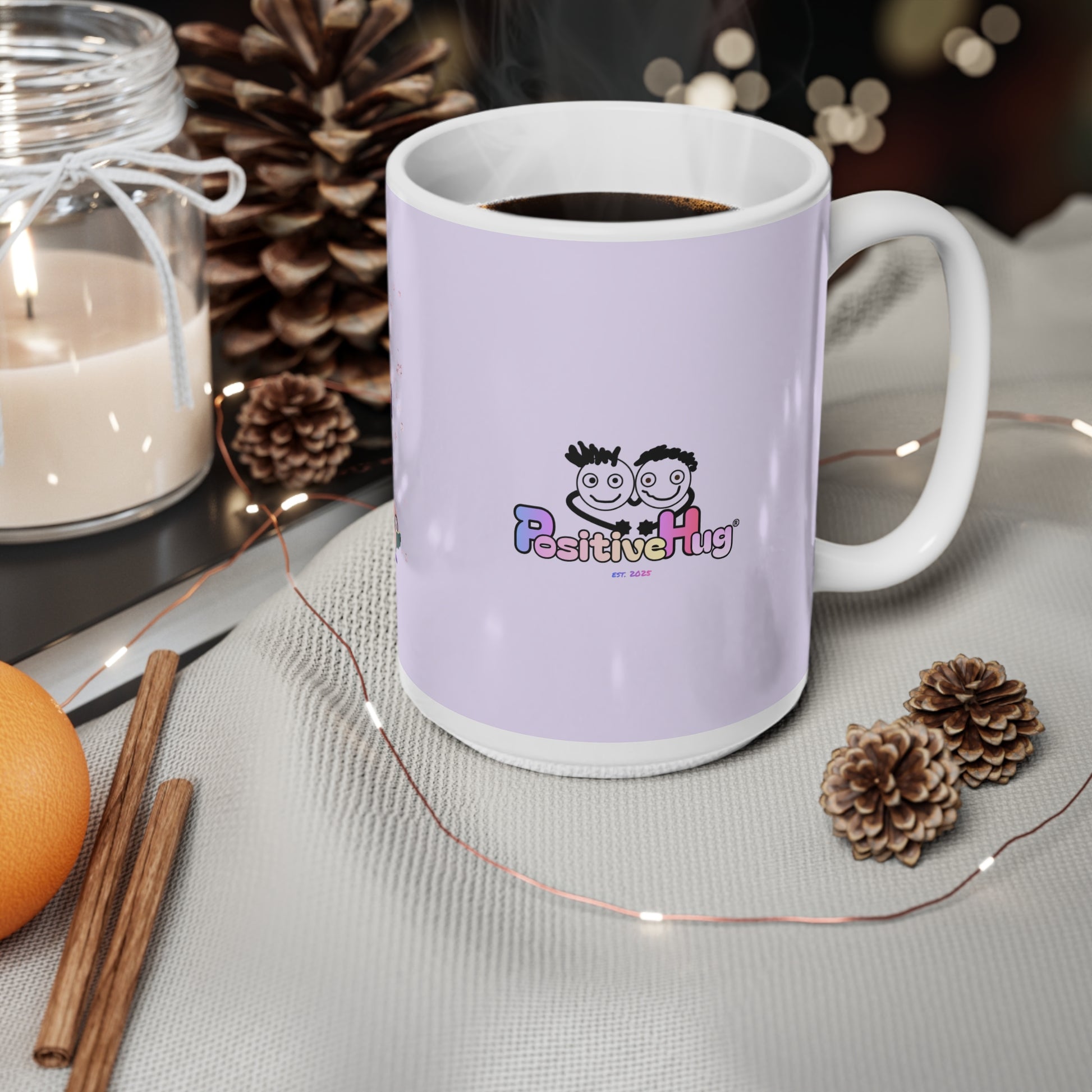 White mug with 'Positive Hug' logo on a table with decorative items