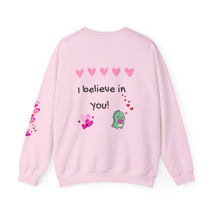 Pink sweatshirt with 'I believe in you!' text and heart designs on a white background