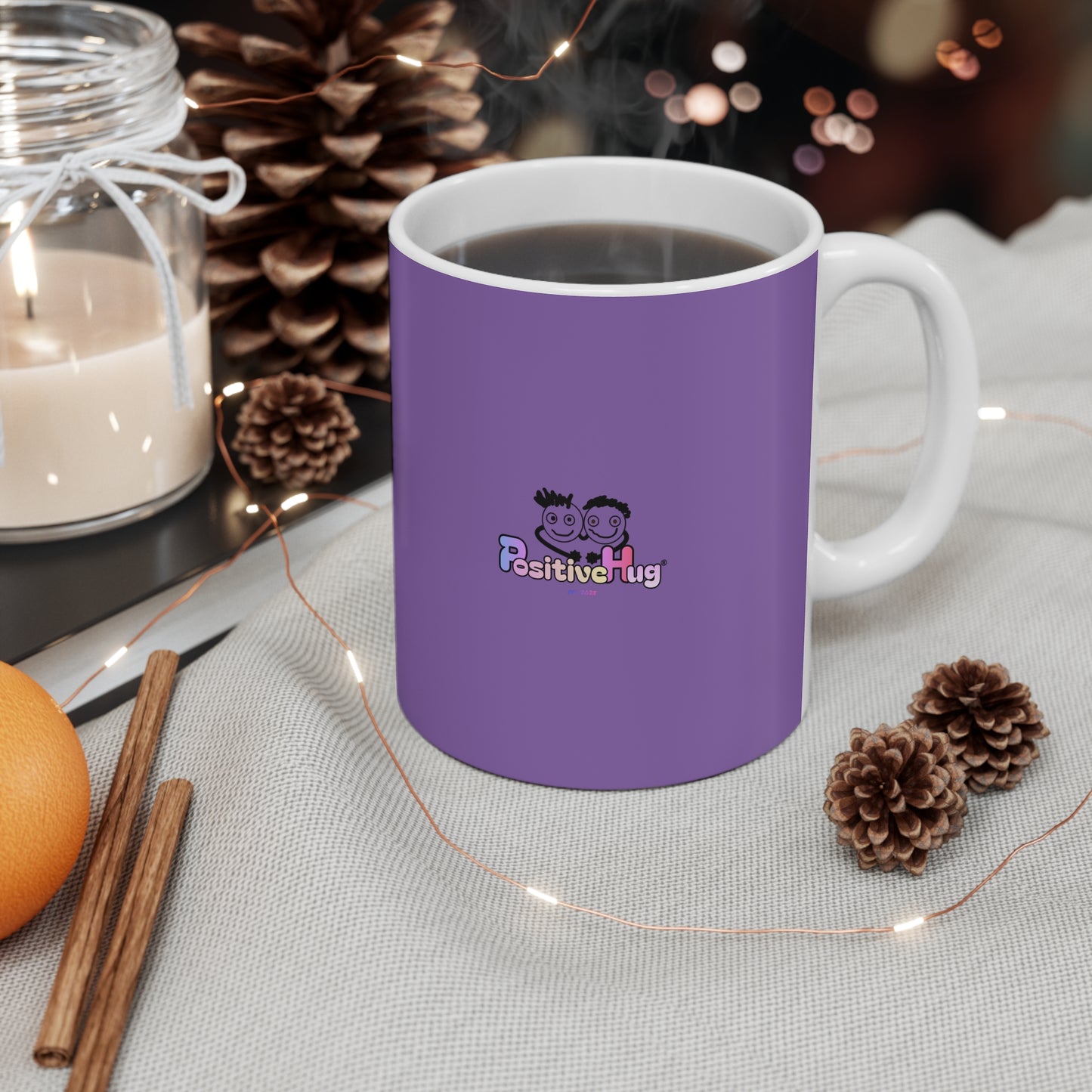 Purple mug with a logo on a table with decorative items