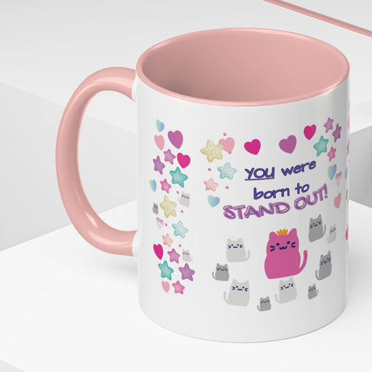 Mug with pink interior and handle, featuring colorful designs and text on a white background