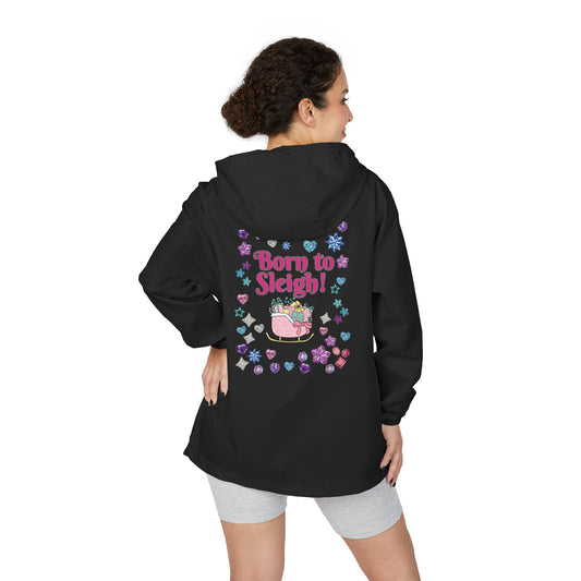 A woman shown from the back wearing a black hooded jacket with a colorful graphic on the back that reads 'Born to Sleigh!' in pink, surrounded by hearts, stars, and a sleigh illustration. She is also wearing light gray shorts against a plain white studio background.
