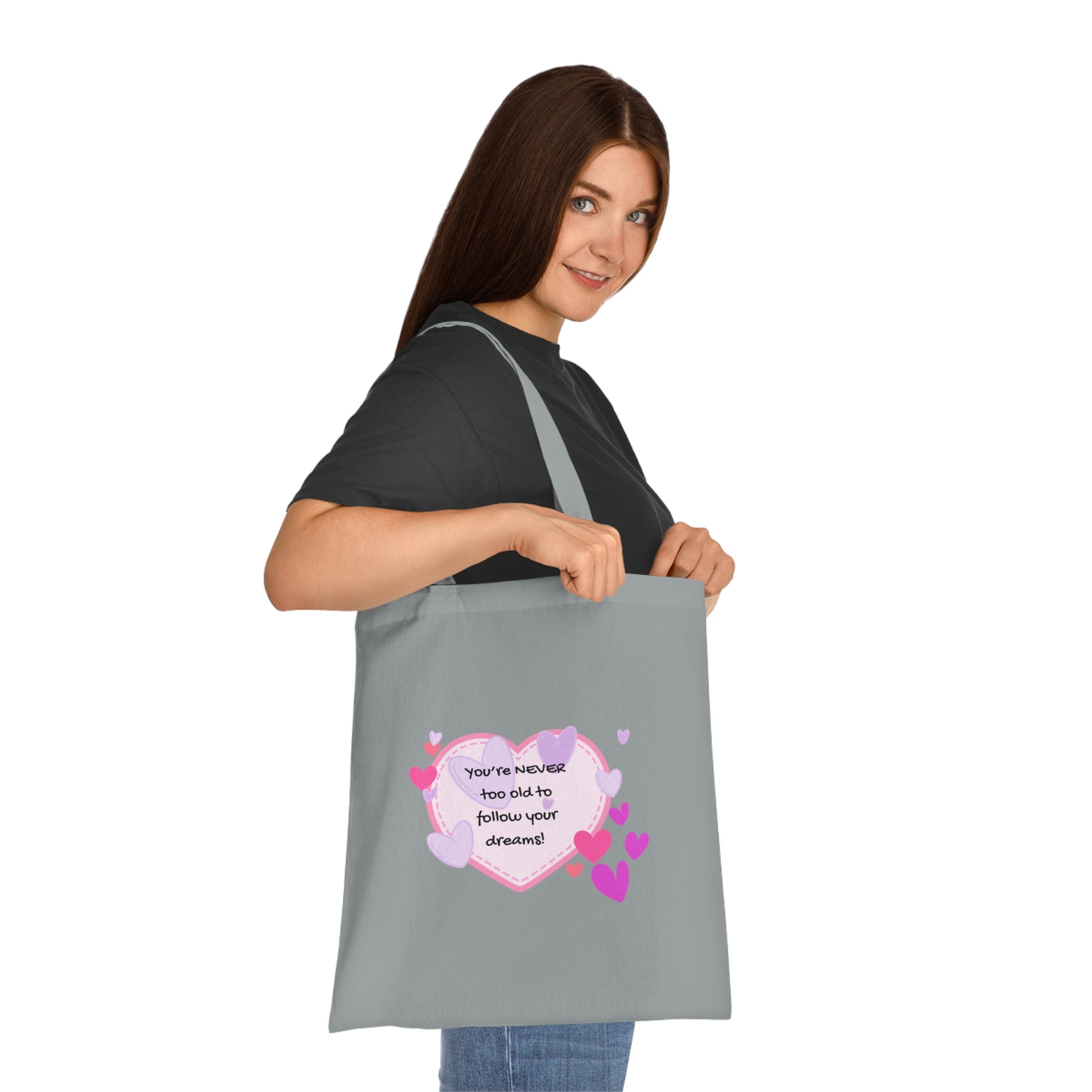 Woman holding a gray tote bag with a colorful design and text on a white background