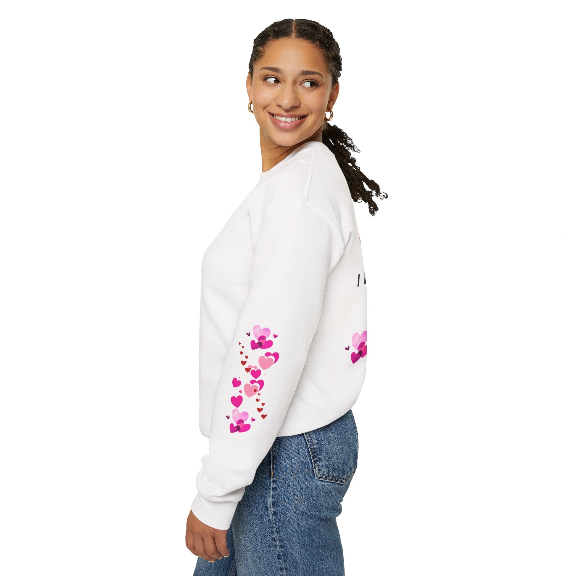 Woman wearing a white sweatshirt with pink heart designs on a white background