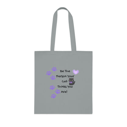 Gray tote bag with a cat-themed message and paw prints on a white background