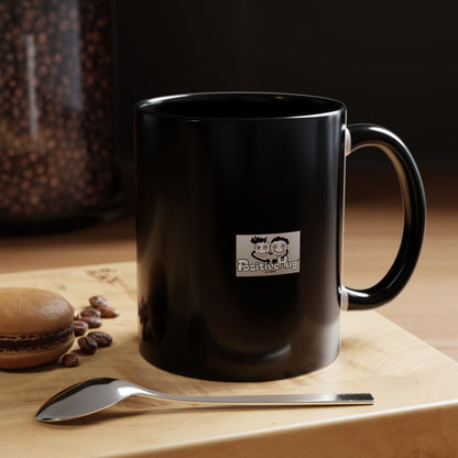Black mug with the PositiveHug logo on a wooden surface with coffee beans and a spoon.