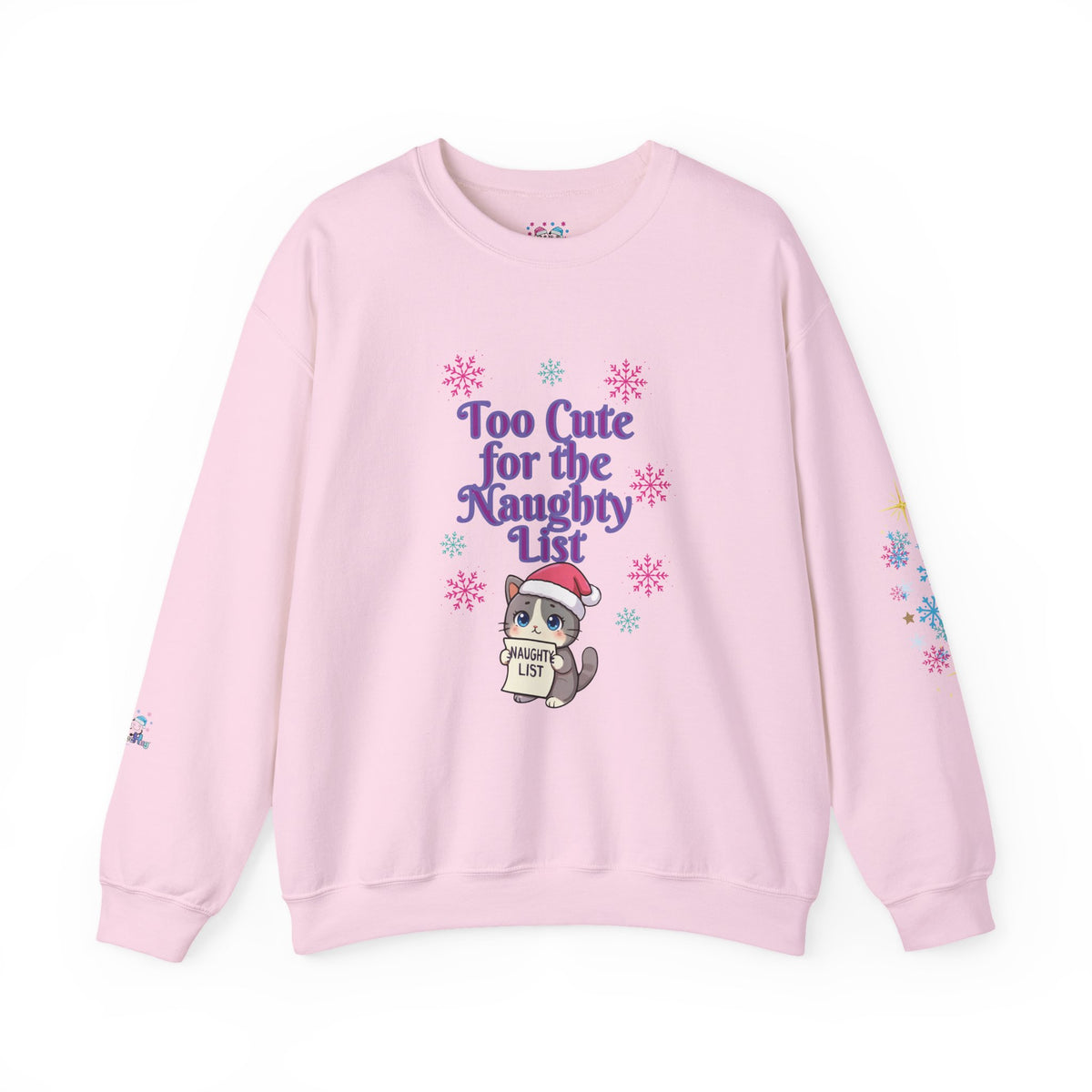 A light pink crewneck sweatshirt featuring a cute cartoon cat wearing a Santa hat and holding a sign that reads 'Cute List' surrounded by purple text that says 'Too Cute for the Naughty List' and colorful snowflake graphics.