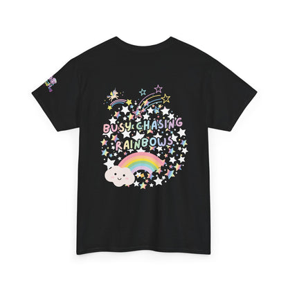 A black short-sleeve t-shirt with a colorful graphic on the front featuring the text 'BUSY CHASING RAINBOWS' surrounded by stars, a rainbow, and a cloud, shown on a plain white background.