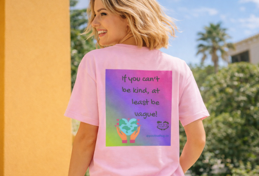 Person wearing a pink t-shirt with a colorful graphic and text outdoors.
